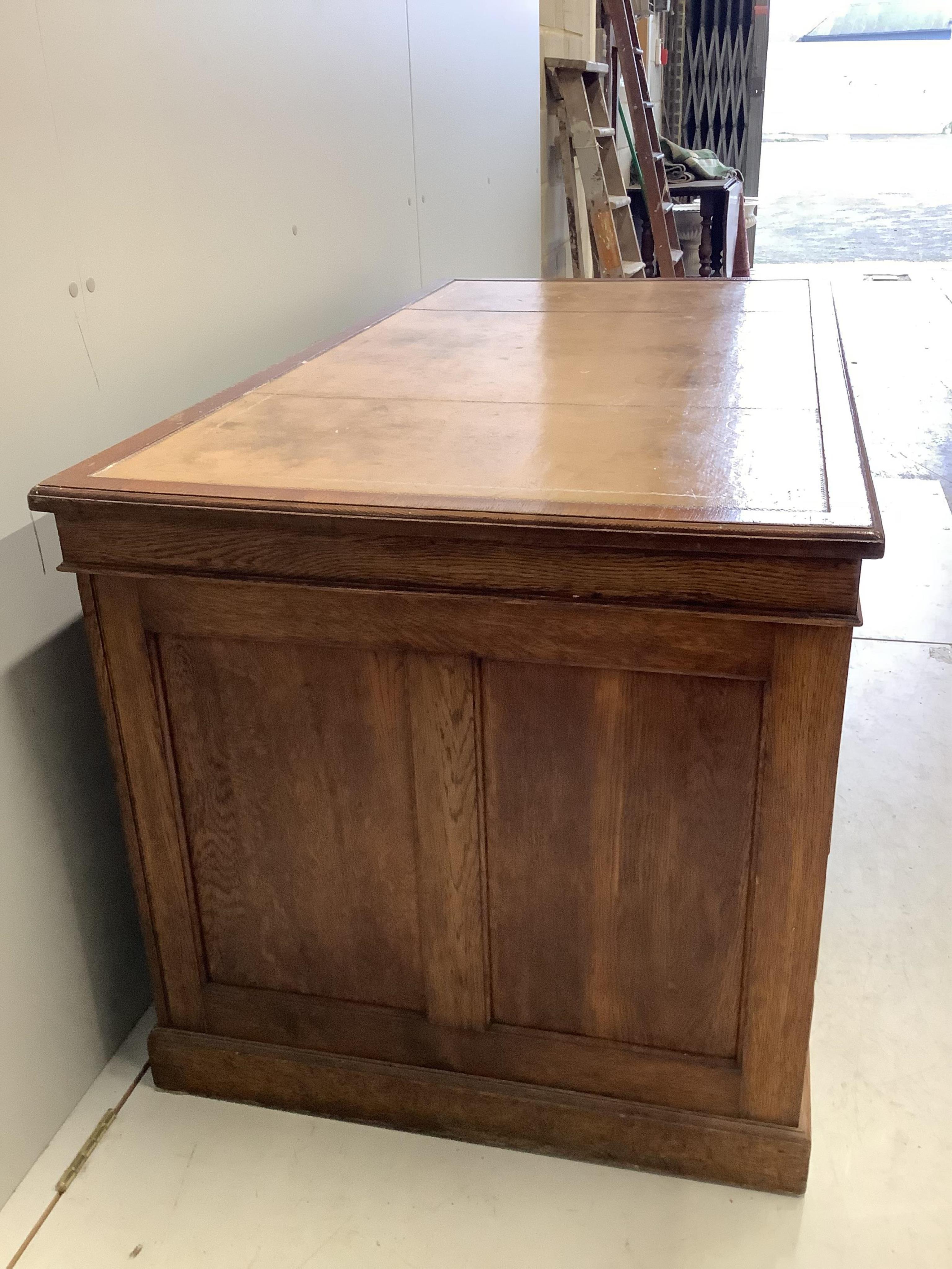 An early 20th century oak pedestal desk, bears George V cypher and stamped John Walsh Ltd Sheffield, width 142cm, depth 75cm, height 75cm. Condition - fair